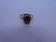 9ct yellow gold dress ring with oval faceted garnet in twisted gold frame, split shoulder, marked 37