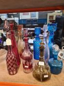 A selection of glass decanters including Bohemian Cranberry and red versions