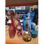 A selection of glass decanters including Bohemian Cranberry and red versions