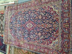 An old Persian rug having all over floral design with central diamond motif, 207 x 138cm