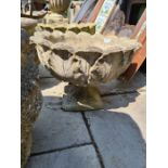 A pair of reconstituted garden pots on pedestal base decorated leaves