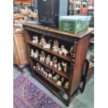 A reproduction Oak open book case having carved frieze