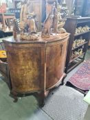 A 1930's burr walnut bow fronted cabinet having central door