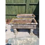 A pair of reconstituted oblong garden troughs with Lion mask decoration both with supports, 93 cm