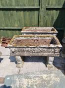 A pair of reconstituted oblong garden troughs with Lion mask decoration both with supports, 93 cm
