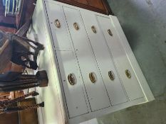 A pair of white painted pine chests having 2 short and 3 long drawers on plinth base