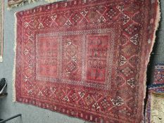 An old bokara style red ground rug having 3 central oblong panels with geometric border, 202 x 149cm