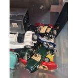 A crate of model cars, mainly 1/18 scale Burago examples, but also a Minichamps Triumph Bonneville 6