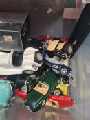 A crate of model cars, mainly 1/18 scale Burago examples, but also a Minichamps Triumph Bonneville 6