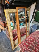 A large modern gilt framed wall mirror and two others