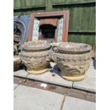 A pair of reconstituted garden urns decorated with horse and cart