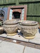 A pair of reconstituted garden urns decorated with horse and cart