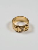 18ct yellow gold buckle ring set with a round cut diamond in square setting, marked 18, London maker