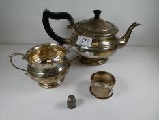 A silver circular tea pot having banded details, and on a circular foot. With a matching two handled