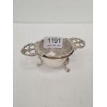 A silver tea strainer on stand two pierced handles and on three paw feet, orbnate border, hallmarked