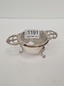 A silver tea strainer on stand two pierced handles and on three paw feet, orbnate border, hallmarked