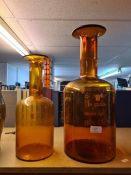 Two Holmegaard amber glass bottles, the largest 48.5cm