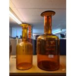 Two Holmegaard amber glass bottles, the largest 48.5cm