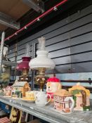 A couple of oil lamps and a selection of novelty teapots in the form of houses, etc