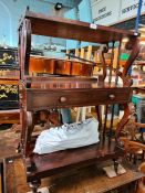 A Victorian rosewood three tier wot not with central drawer on lyre endsupports, 68.5 cms