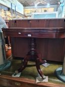 A 19th Century mahogany foldover card table with crossbanded top on turned pillar