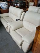 A pair of modern cream leather two seat sofas with reclining mechanisms, and a matching electrical r