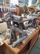 An African Tribal style oblong wooden bench the ends decorated figures in squatting position, 136cms