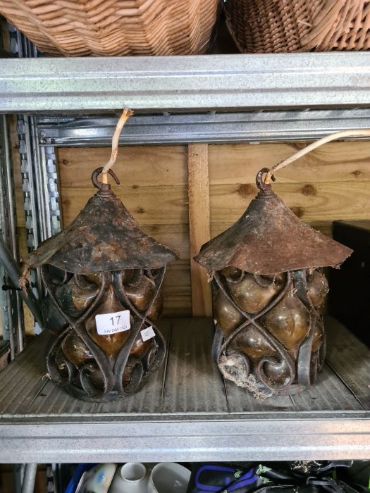 A pair of wrought iron lanterns having coloured glass shades