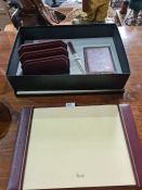A Harrods maroon leather desk set in fitted box, including blotter and paper knife, etc