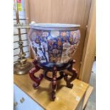 A large oriental pot on stand, decorated inside with lion head goldfish