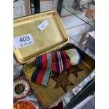 A trio of medals including two stars and a World War I Christmas tin