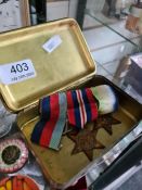 A trio of medals including two stars and a World War I Christmas tin