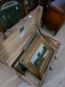 A vintage trunk containing various framed pictures and prints