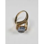 9ct yellow gold dress ring with crossover square textured mount and central blue paste step cut ston