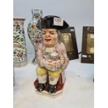 A 19th Century Toby jug of seated man holding large jug