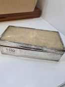 A silver engine turned cigarette box having possibly snake skin lid. 18.5cm x 9cm approx. Hallmarked