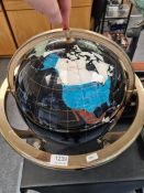 A modern table top globe having inlaid mineral countries