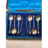 A cased set of six silver teaspoons and one sugar tongs terminating in decorative finial. Hallmarked