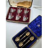 A cased set of four Edwardian decorative silver gilt spoons having embossed and engraved details, te