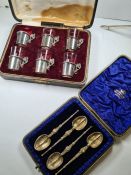 A cased set of four Edwardian decorative silver gilt spoons having embossed and engraved details, te