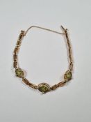 Unmarked yellow metal two gate link bracelet with three oval panels, set peridot and seed pearls, wi