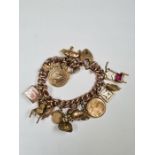 9ct yellow gold charm bracelet hung with 16 charms, examples to include two rolled gold seals and 9c