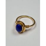 14K yellow gold dress ring set with oval cabouchon blue hardstone with twisted frame and ropetwist s