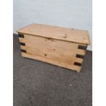 A smaller stripped pine blanket box