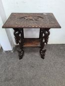 A Burmese carved two tier occasional table with lion carving