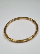 9ct yellow gold hinged bangle with twisted top, marked 375, 6cm diameter, maker LW, approx 4.88g