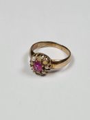 Antique yellow gold cluster ring set with central round cut ruby, surrounded by seed pearls, pearls