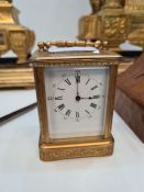 A small French carriage clock having engraved scroll decoration, enamel dial and bevelled glass, 8.5
