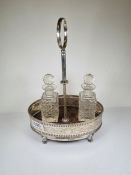 A Georgian silver cruet stand having a decorative engraved body, pierced details and beaded rim on f