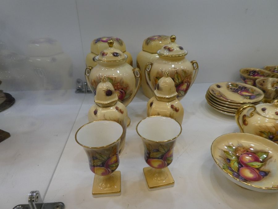 A pair of Aynsley urns by D. Jones decorated fruits, a pair of hexagonal ginger jars (one lid broken